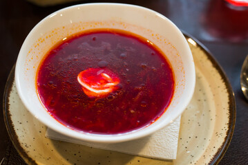 Beetroot soup with sour cream in bowl