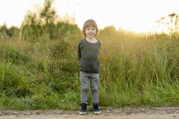 Cute little boy playing outdoors on sunny autumn day. Child exploring nature. Fall activities for kids.