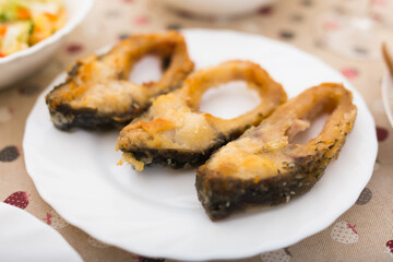 Pieces of the middle part of the carp baked on a white plate