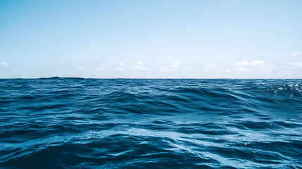 Dark navy blue ocean waves gently rolling under a clear sky, creating a serene and tranquil marine atmosphere