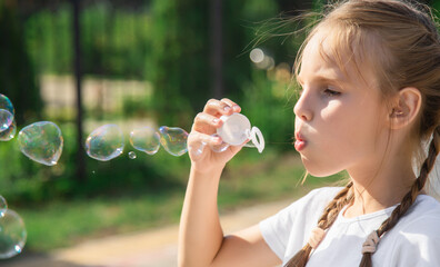 Little girl blowing soap bubbles
