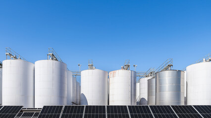 Wine processing plant with large fermenting and storage tanks and installed solar panels in rural South Australia on a bright day