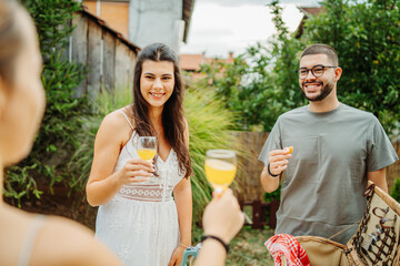 Group of three friends or family having picnic in backyard or garden