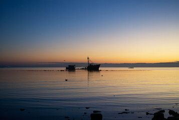 a sunken ship on a beach at sunset