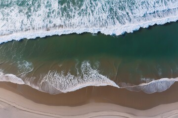 Fototapeta premium Stunning Aerial View of Calm Waves Embracing Sandy Beach for Your Ideal Summer Getaway