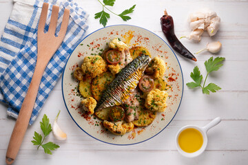 Baked mackerel with braised cauliflower and cherry tomatoes. Top view table.