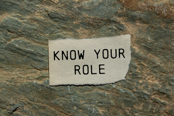 Know your role message written on ripped torn paper piece on stone background. Conceptual know your...