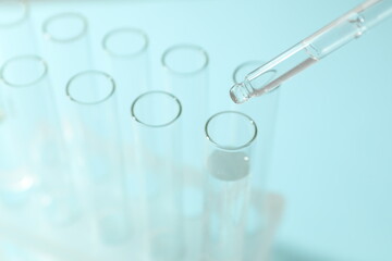 Laboratory test tubes with pipette on colored background