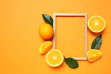 Summer tropical composition with a wooden frame. Green leaves and tropical orange fruits on a colored background. Summer concept. Flat lay, top view, copy space