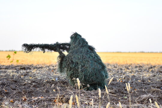Camouflaged hunter is sniping his prey.
