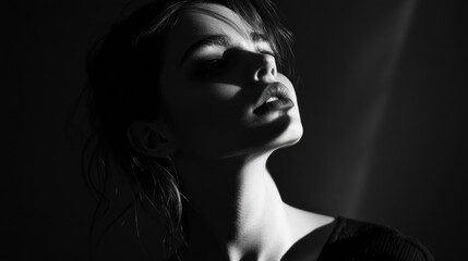 A dramatic black-and-white portrait highlighting facial features and shadows.