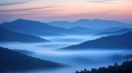 Fototapeta premium Serene mountains shrouded in mist during twilight, creating a tranquil landscape.