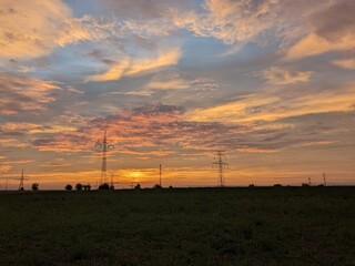 A dramatic view of Ukraine’s power grid at dawn, highlighting high-voltage pylons as critical infrastructure vulnerable to war-related threats and energy crises