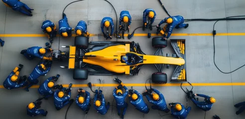 Gordijnen Formula 1 pit crew in blue uniforms surrounds a yellow racing car, performing a pit stop with precision and speed. © master1305