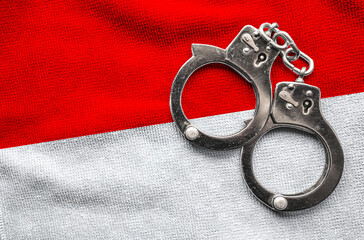 Flag of Indonesia and police handcuffs. Crime and offenses in country Concept
