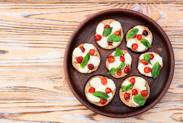 Italian mini pizza . Aubergine (eggplant ) with mozzarella cheese and basil . On rustic background