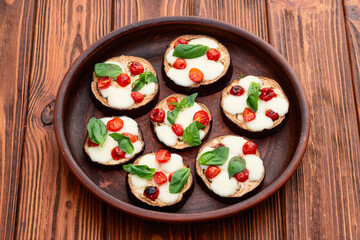Italian mini pizza . Aubergine (eggplant ) with mozzarella cheese and basil . On rustic background