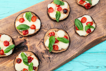 Italian mini pizza . Aubergine (eggplant ) with mozzarella cheese and basil . On rustic background
