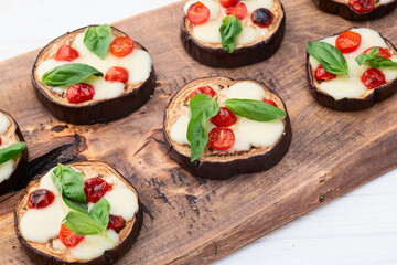 Italian mini pizza . Aubergine (eggplant ) with mozzarella cheese and basil . On rustic background