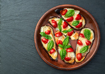Italian mini pizza . Aubergine (eggplant ) with mozzarella cheese and basil . On rustic background