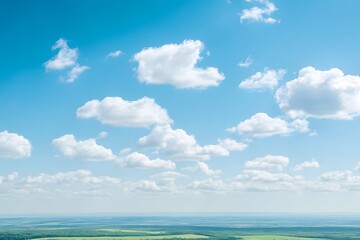 Clear blue sky with a few fluffy clouds and a green landscape below