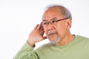 Fototapeta premium Portrait Asian old man with glasses and a beard listening to sound something, possibly engaged in conversation or trying to understand a message, hand on ear hearing a rumor isolated white background