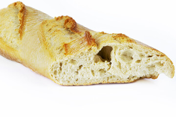 Closeup of a sliced French baguette with a crispy crust and airy texture isolated on a white background. With clipping path. Copy space.