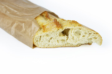 Freshly baked French baguette  in a paper bag. Traditional homemade white bread wrapped in rustic brown paper. Isolated on a white background. Closeup. With clipping path. Copy space