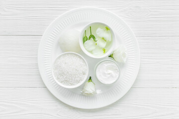 Spa set with cosmetic products with white flowers, top view
