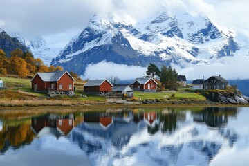 Fototapeta premium A small beautiful village in front of a snow capped mountain at a calm lake with reflection 