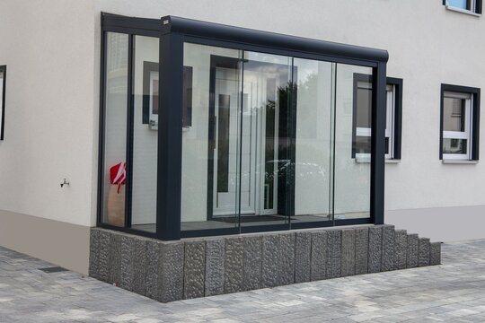Windfang mit Alu-Profilen und Glas am Eingangsbereich eines Einfamilienhauses