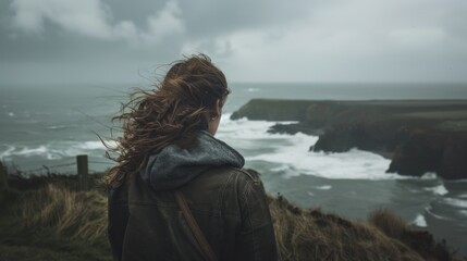 Fototapeta premium Windy coastal view with a person admiring the ocean cliffs