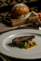 Portion of meat with vegetables ready to eat with bread in the background
