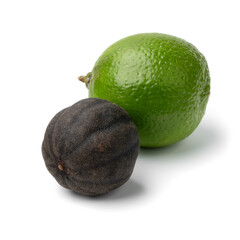 Whole dried black lime, loomi, and a fresh green lime isolated on white background close up