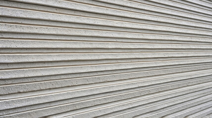 Close-up of a light wall with horizontal cladding showing the texture and pattern of the concrete grooves