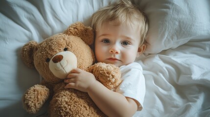 Infant cuddling a plush toy while in bed