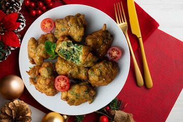 Spinach fritters, traditional Spanish tapa. Top view table with Christmas decoration.