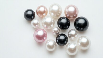 A group of pearls in different sizes and colors--white, pink, and black--arranged in a geometric pattern on a white background.