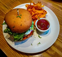 Vegan burger with curved fried potatoes.