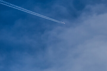 An aircraft flying high in the blue sky creating a minimal background. 