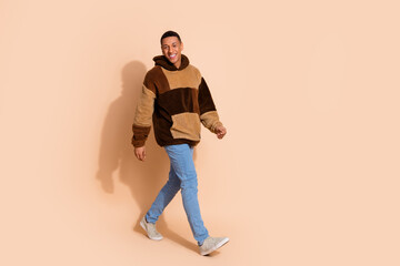 Fototapeta premium Photo of good mood funny nice man wear stylish clothes walk empty space isolated on beige color background