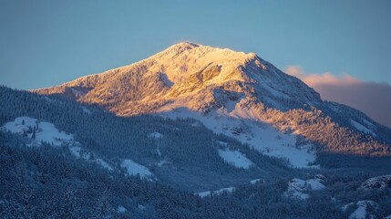 A majestic snow-covered mountain basking in warm sunlight during a serene winter evening.