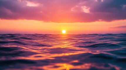 Obraz premium A serene sunset over calm ocean waters, creating a tranquil and picturesque atmosphere.
