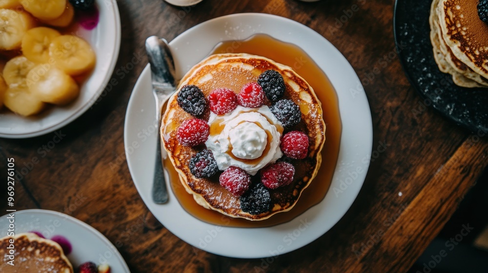 Canvas Prints A delicious stack of pancakes topped with berries and whipped cream, served with syrup.