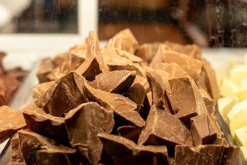 Close-up of assorted chocolate chunks including white and milk chocolate in a display case