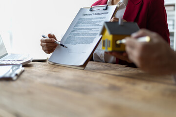 Businessman and real estate agents discussing documents signing a legal purchase of a house.