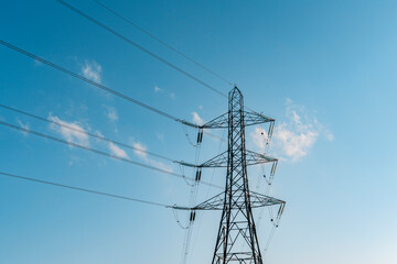 Towering Power Lines Stretch Against a Clear Blue Sky During a Bright Afternoon