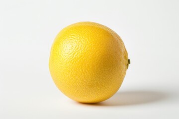 A lone orange sits on a white surface