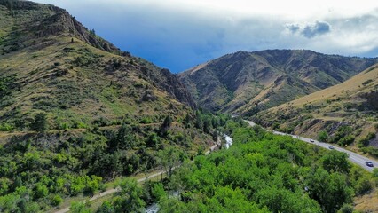 Aerial view of a lush valley with a winding river and road.