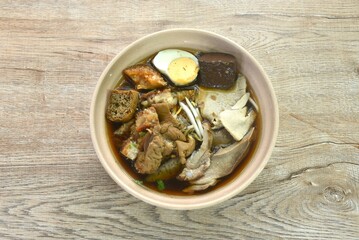 boiled slice pork and entrails topping blood with egg in herb brown soup on bowl 